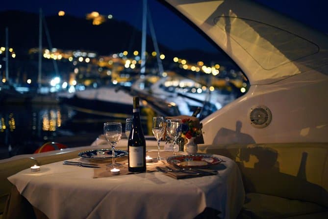 Cena elegante su una barca con tavolo apparecchiato e vista sul mare